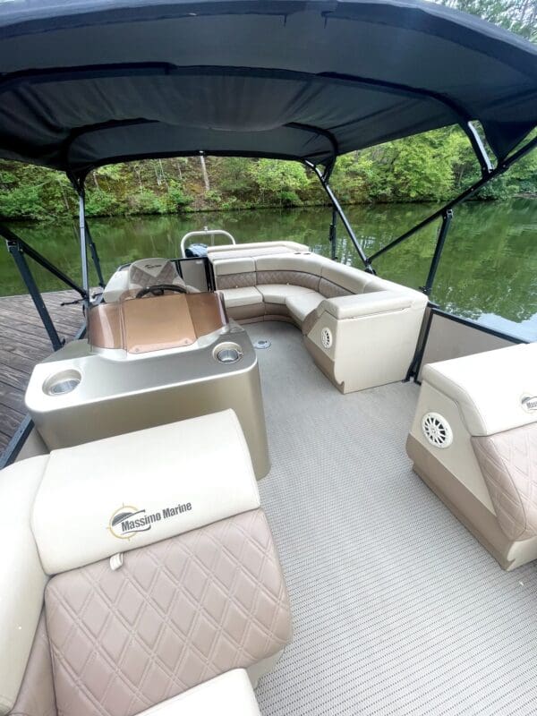 Tan pontoon boat with a canopy.