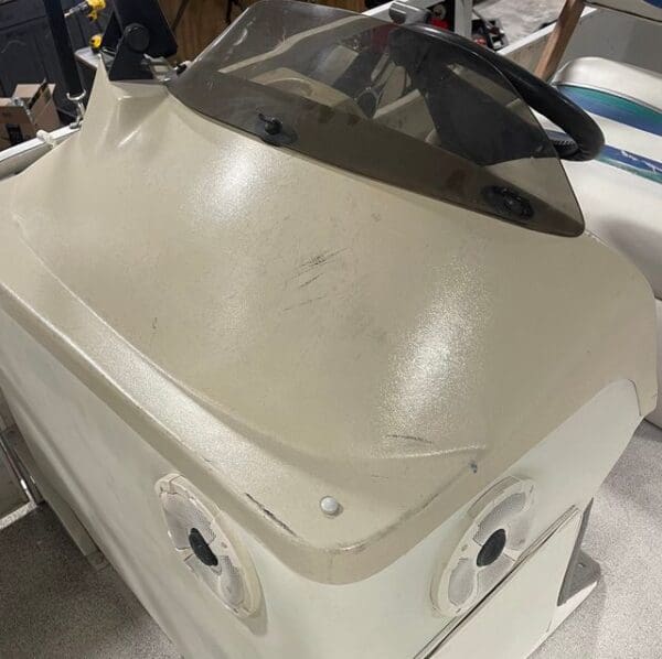 White boat console with speakers and windshield.