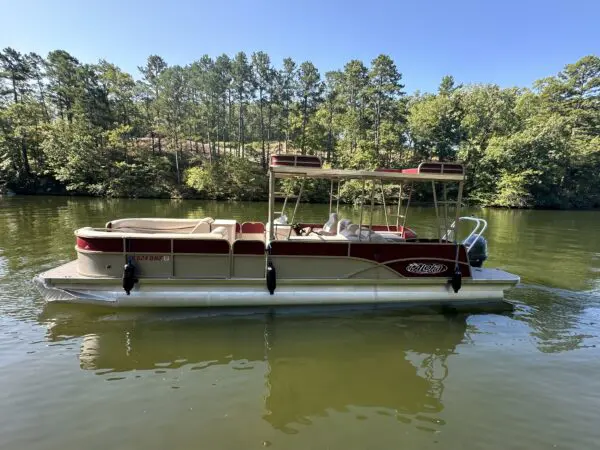 White pontoon boat on a lake.