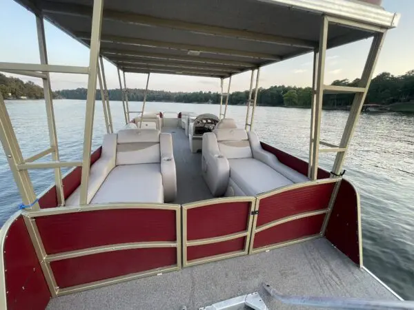 A red and white pontoon boat on a lake.