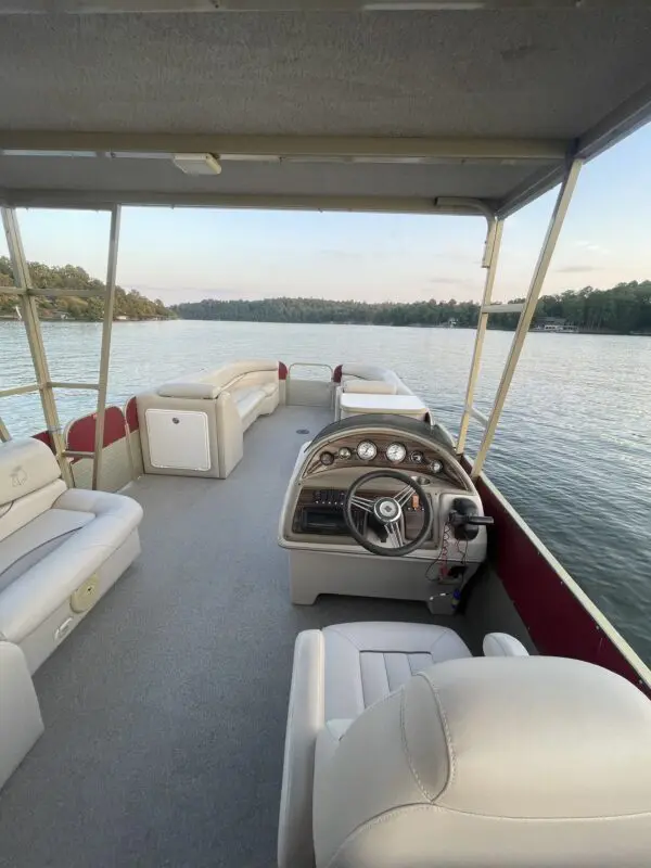 Steering wheel and seats inside a pontoon boat.