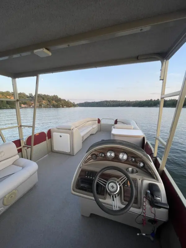 Pontoon boat interior with steering wheel.